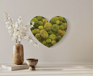 Heart-shaped lush moss wine barrel art in distressed metal frame for indoor decor.