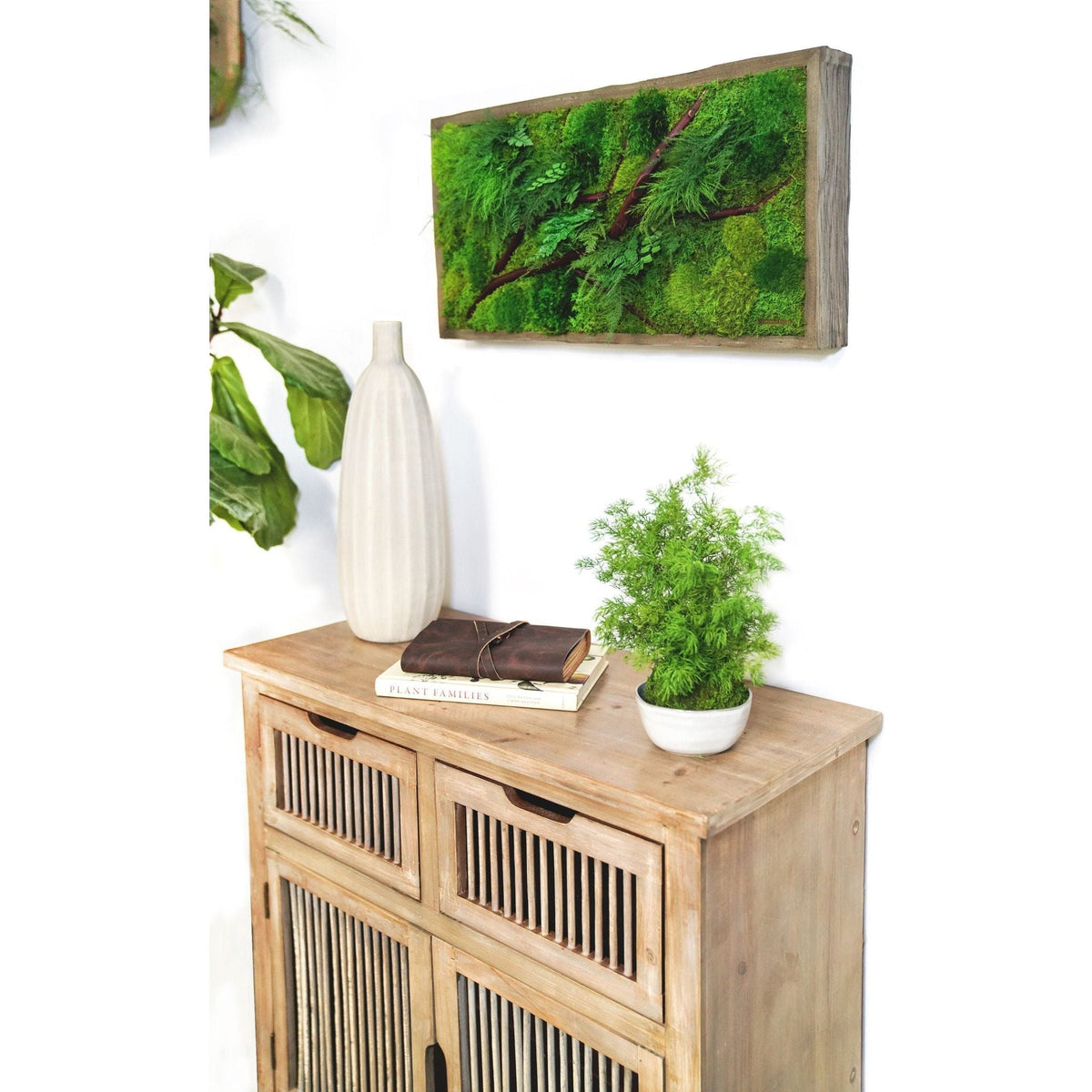 Red Branch 12” x 24” Plant Painting® in rustic grey frame on wall above wooden cabinet with decor.